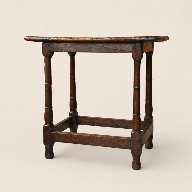 A compact English oak tavern table dating to the late 17th or early 18th century. Its broad single-plank top retains a...
