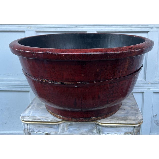A large antique Chinese lacquered wood bowl, basin or tub contracted from wooden staves and iron hoop binding with wide...