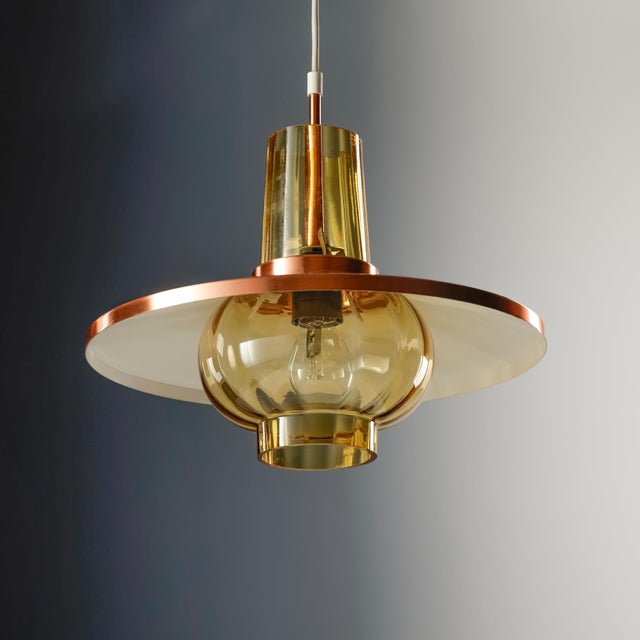 This german hanging lamp / pendant light was produced by peill & putzler in the 70s! a large, polished copper shade is...