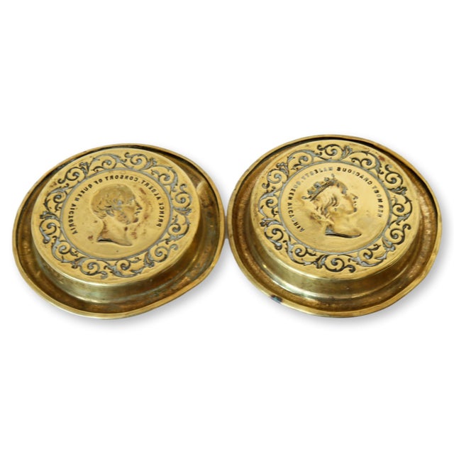 This rare matched pair of brass portrait coasters features finely cast profiles of a youthful Queen Victoria and Prince...