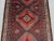 This vintage Afghan Baluchi wide runner rug features a stunning tribal diamond pattern in warm tones of red, brown, and...