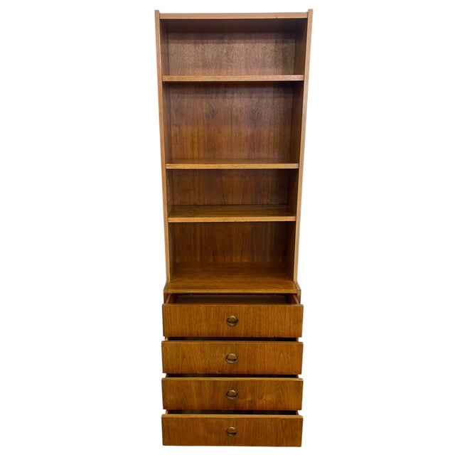 Vintage mid century modern bookshelf cabinet featuring an open upper shelving section above a four-drawer storage base....