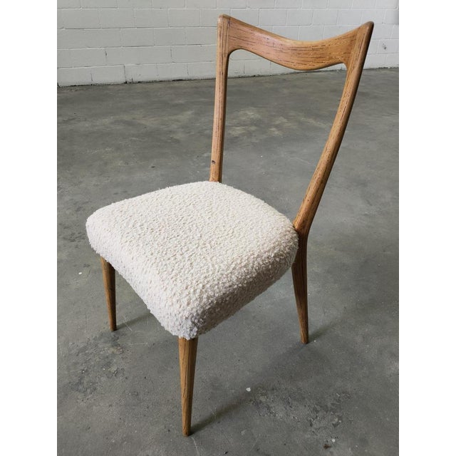 Chairs with varnished walnut wood structure, Boucle fabric upholstery, 1970s. Measurements: seat height 43cm, width 46cm,...