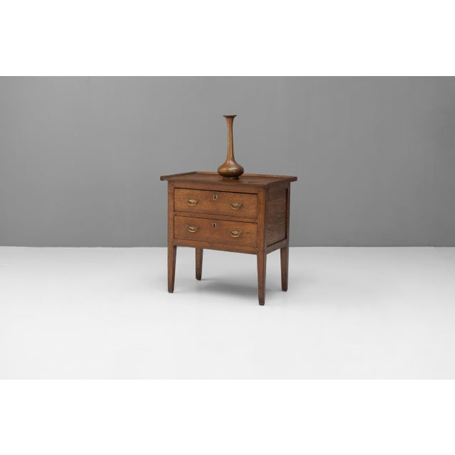 Early 19th century two drawer oak chest on tapered legs, original feet and handles with a gallery top. Burn on top. France...