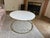 White round marble coffee table with iron legs in a brass finish. Purchased from Anthropologie around 2017 (although there...