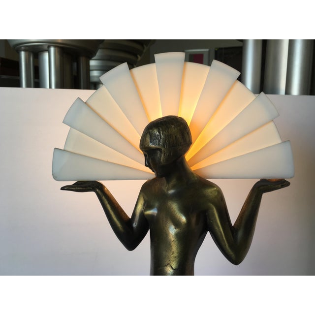 This striking Art Deco-style lamp showcases a beautifully sculptural nude figure of a woman inspired by Egyptian motifs,...
