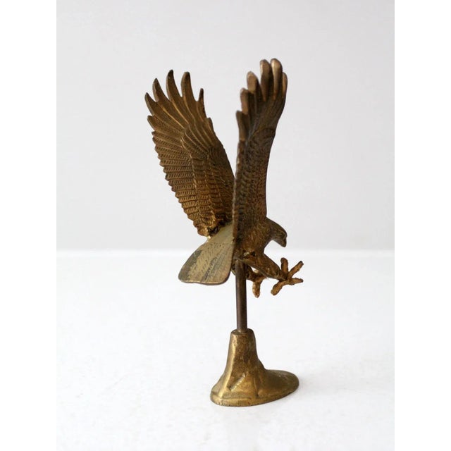 This is a vintage brass eagle sculpture. An eagle preparing to land atop a rock shapes this figurative sculpture. Lovely...