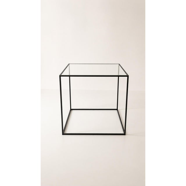 Designer coffee table in metal and glass. Minimalist style with a black metal frame and a clear glass top. Modern and...