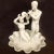 Beautifully finished in an ivory-hued glaze, this ambitious and rare sculptural grouping of a Pan and Nymph with flute and...