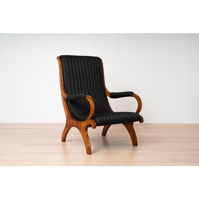 An exceptional 19th-century armchair in the Biedermeier style, likely originating from Germany and crafted from beautiful...