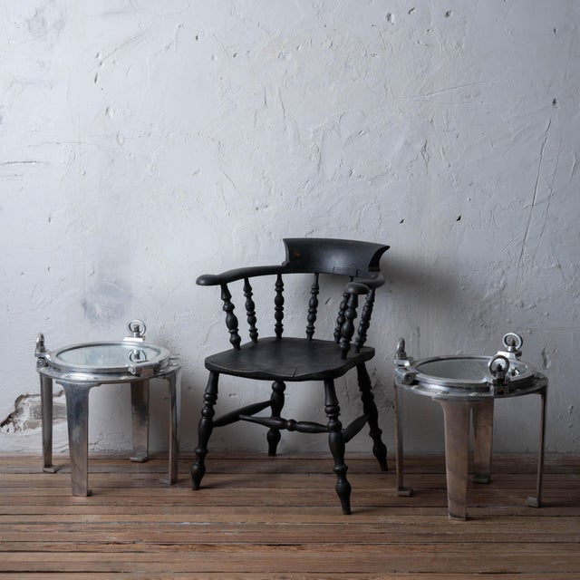 A pair of porthole cover side tables made from genuine ship porthole covers, with beveled mirror tops and aluminum legs,...