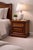 A beautifully preserved 1970s traditional revival nightstand in a rich brown mahogany finish, featuring fluted corner...