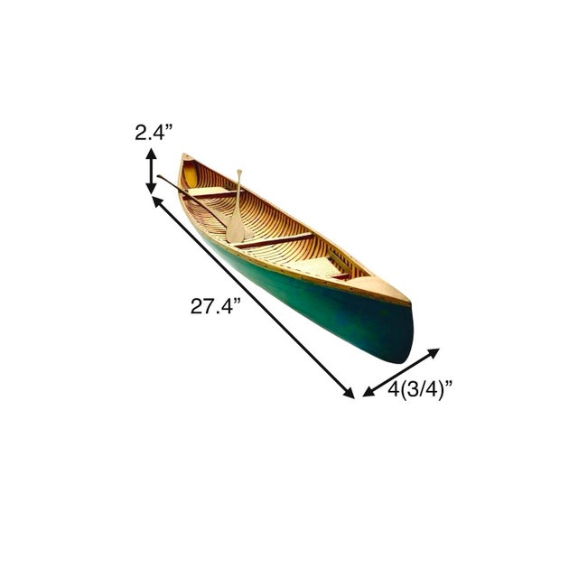 This vintage canoe model with a paddle, designed in a large wood rowboat style, serves as a unique and charming piece of...