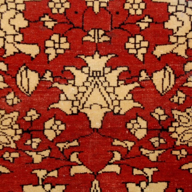A 19th century Persian Saruk Farahan carpet with central floral medallion on an indigo background inside a crimson frame...