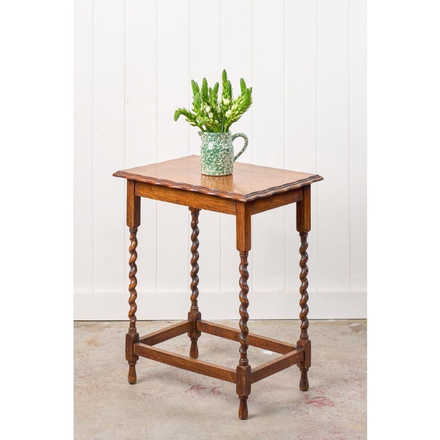 This charming honey oak side table features turned barley twist legs that are complemented by a rich tiger oak wood grain...