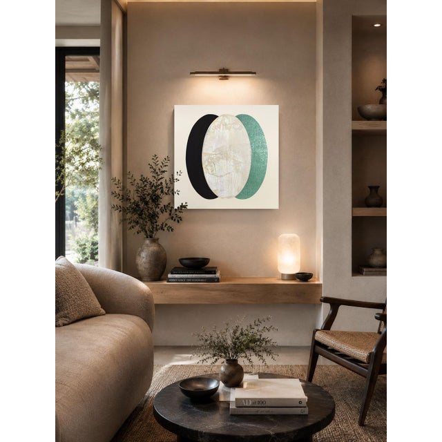 Three vertical ovals overlap here, black, pale ivory, and deep teal, like a stack of lenses shifted just out of alignment....