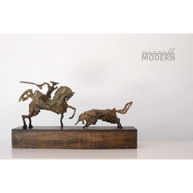 Incredible vintage brutalist bronze sculpture of a picador battling a bull on a wooden base. This piece is rustic and...