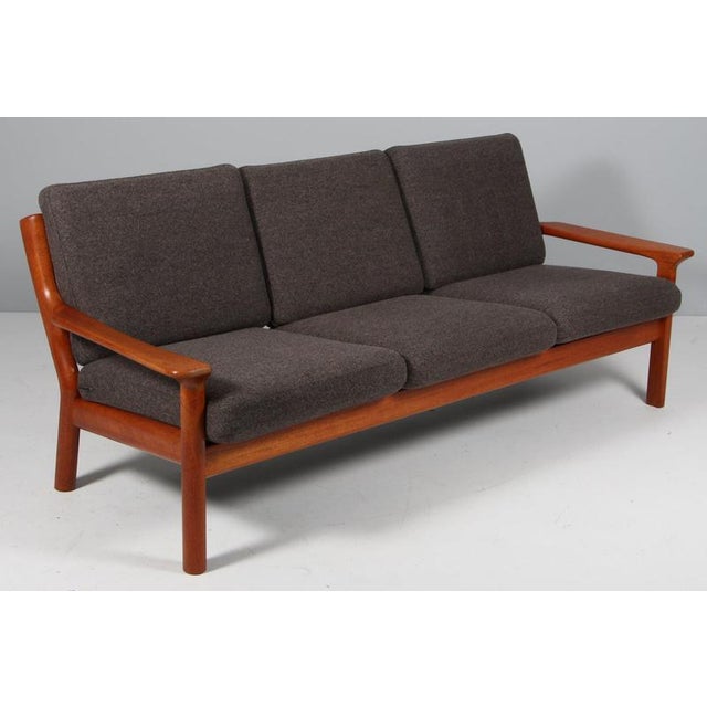Juul Kristensen three seat sofa in teak. Cushions upholstered with grey wool fabric. Made by Juul Kristensen in the 1960s....