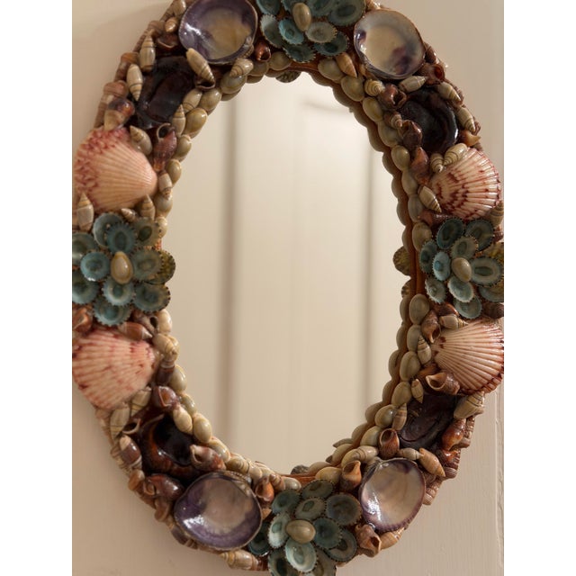 Charming vintage oval mirror featuring an intricately hand-applied collection of natural seashells in soft coastal hues....
