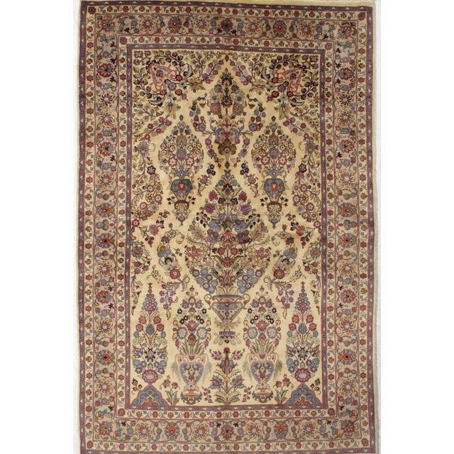 Hand-knotted Persian Kashmar wool rug with an ivory field featuring a symmetrical tree-of-life and vase design, filled...