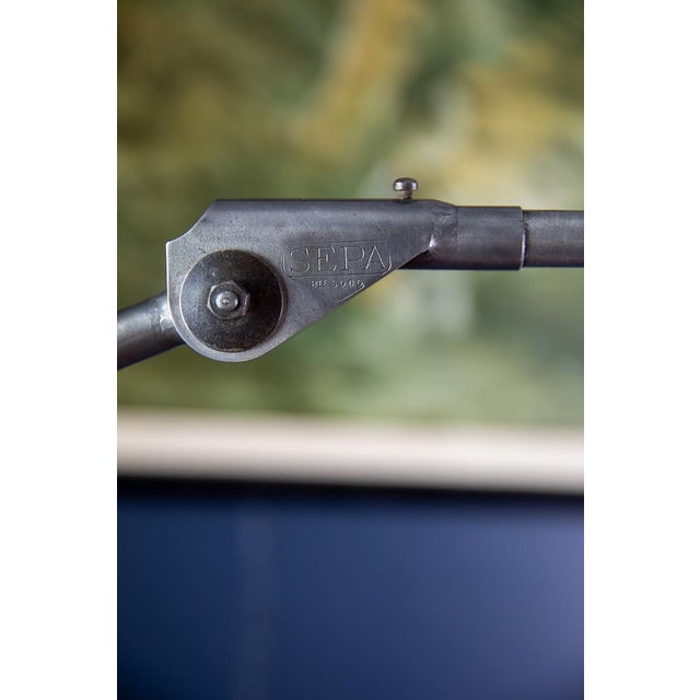 Industrial machine lamp with a two-part swivel arm made of steel tubing, a conical aluminum shade, and a switch on the...