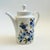 A mid century Bavarian porcelain teapot. Made by Schumann Porcelain of Arzberg, Germany. Glossy white glaze with a blue...