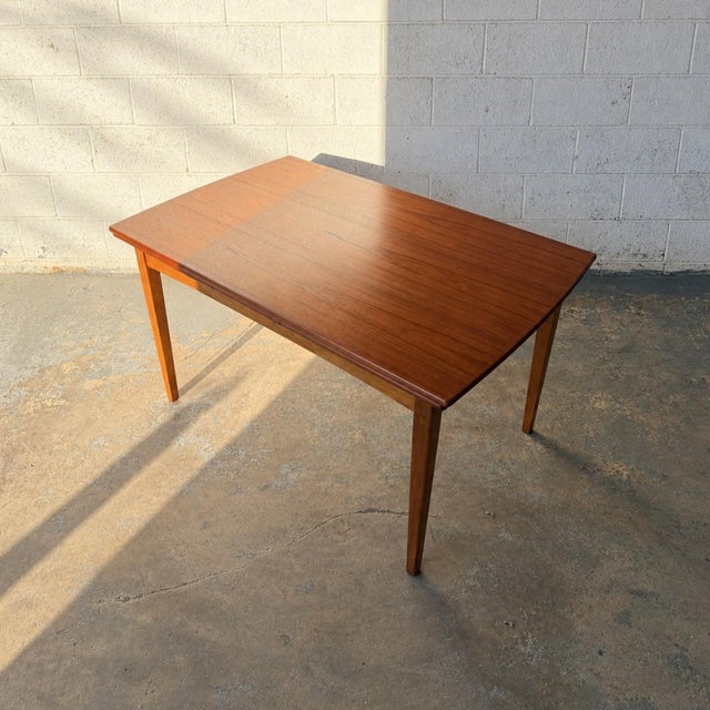 A Danish teak and oak dining table from the 1950s, with a beautifully figured top that gives this piece its character....