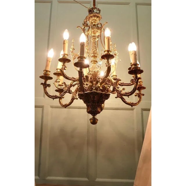 This splendid very large Chateau chandelier is made in Gilded Brass with twelve upward curved arms radiating from an...