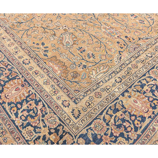 An antique Persian Tabriz carpet featuring a golden field beneath a lively trellis of arabesque vinery and finely-drawn...