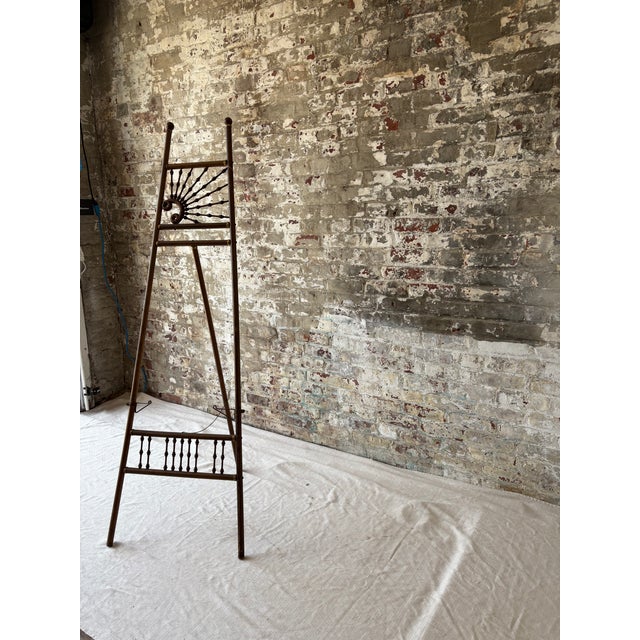 Elevate your space with this stunning antique wooden easel, featuring beautiful spindle detailing and subtle brass...