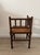 Antique corner chair in dark-stained wood, remarkable for its legs and back adorned with numerous turned, bead-like...