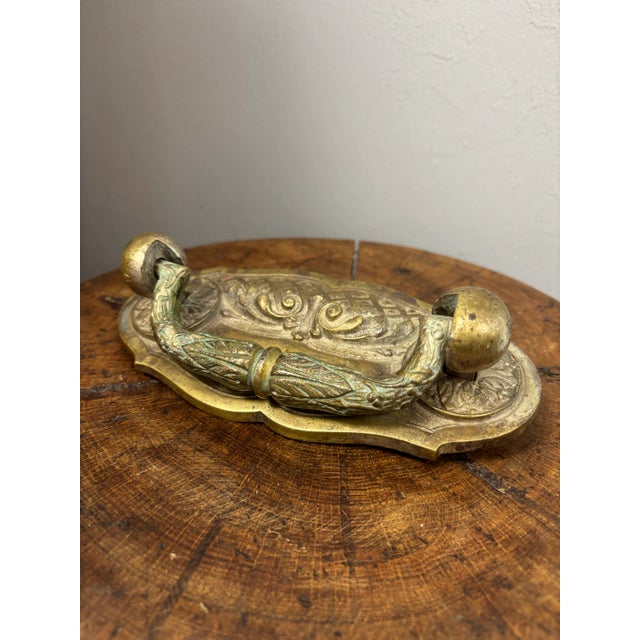 This antique English brass door knocker is a striking example of timeless craftsmanship and enduring design. Beautifully...
