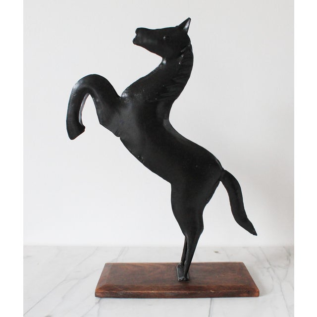 Vintage folk art metal rearing horse figure on wood base. Some age wear to painted black finish. Made in India.