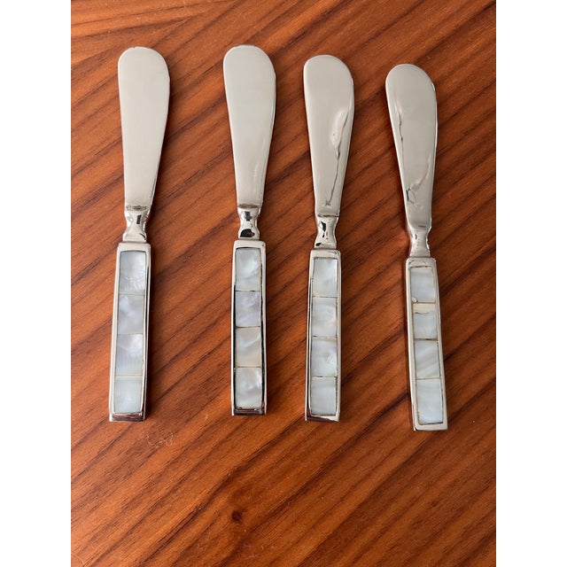 A gorgeous set of four stainless spreaders featuring inlaid mother of pearl tiles. Perfect for your coastal summer soirée...