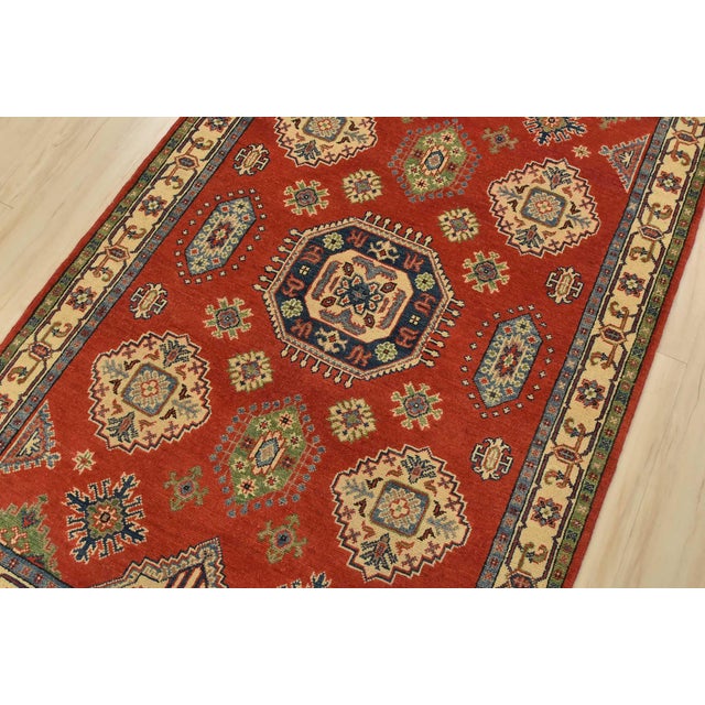 A tribal Caucasian Kazak rug hand-knotted with fine wool on a cotton foundation. This rug features geometric motifs set...