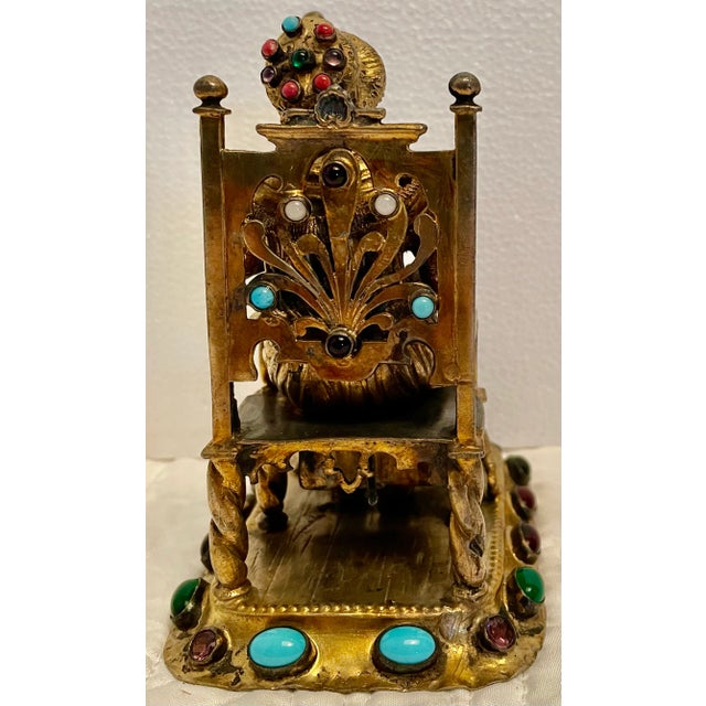 Gold washed metal detailed figure of a woman seated in a chair. Beautifully gem set with cabochon stones.