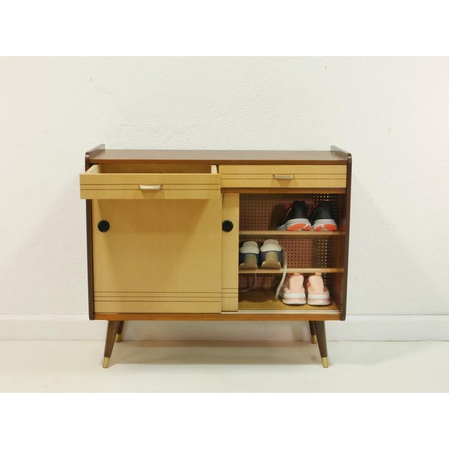 This charming vintage shoe cabinet dates back to the 1960s and combines functionality with typical mid-century design. The...