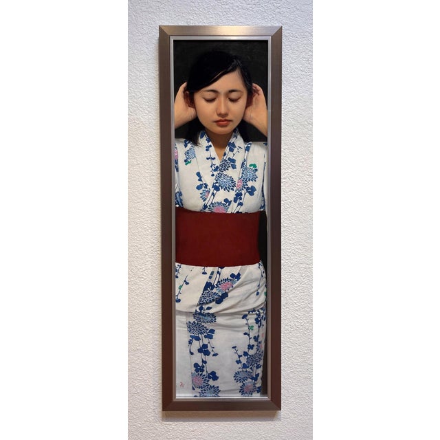 The artwork features a serene figure adorned in a traditional kimono, her eyes gently closed as she appears to be in deep...