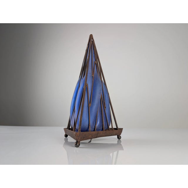 This stunning vintage table lamp features a geometric pyramid-shaped iron frame enclosing a dazzling hand-blown blue glass...