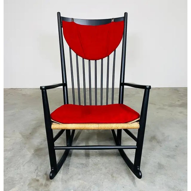 A rare 'black edition' of the iconic Hans J. Wegner J16 rocking chair having perfect Rush seat with original red hanging...