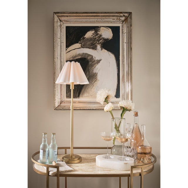 The Polly Buffet Table Lamp showcases sophistication with its single scalloped shade, casting a warm and inviting glow...