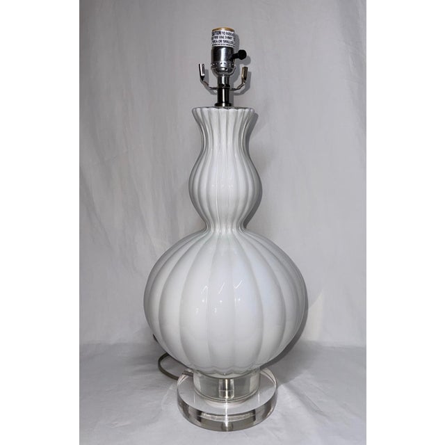 Ribbed white glass double gourd lamp with lucite base. 21” height to socket. 9.5” diameter at widest. 6” base diameter.