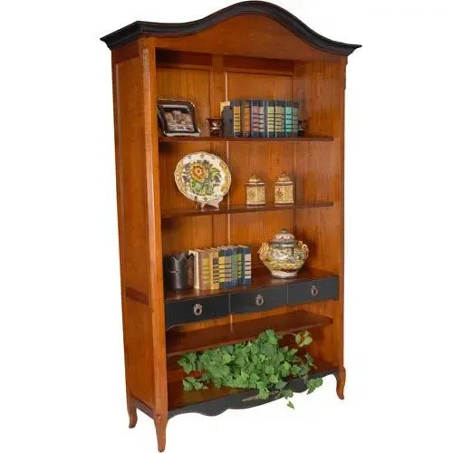 Handcarved wooden bookcase with three drawers and five shelves in a natural wood finish accented with rubbed ebony....