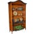 Handcarved wooden bookcase with three drawers and five shelves in a natural wood finish accented with rubbed ebony....