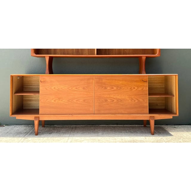 This vintage Drylund Danish teak hutch and sideboard embodies mid-20th-century Scandinavian design at its finest, pairing...