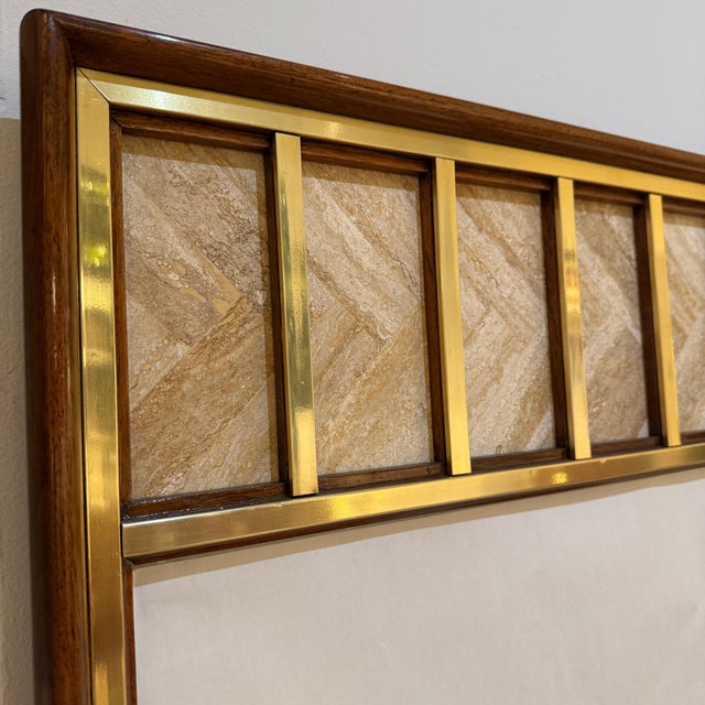 A modernist mirror designed by Edward Wormley. Mahogany with patinated brass trim details with seven panels of travertine...