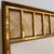 A modernist mirror designed by Edward Wormley. Mahogany with patinated brass trim details with seven panels of travertine...