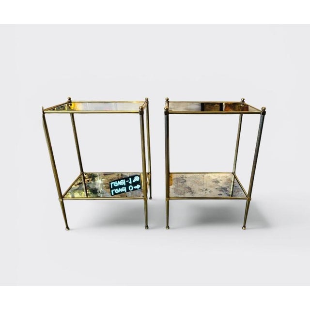 Pair of neoclassic two-tiered brass and glass side tables with oxidized mirrors. Attributed to Maison Jansen. In very good...