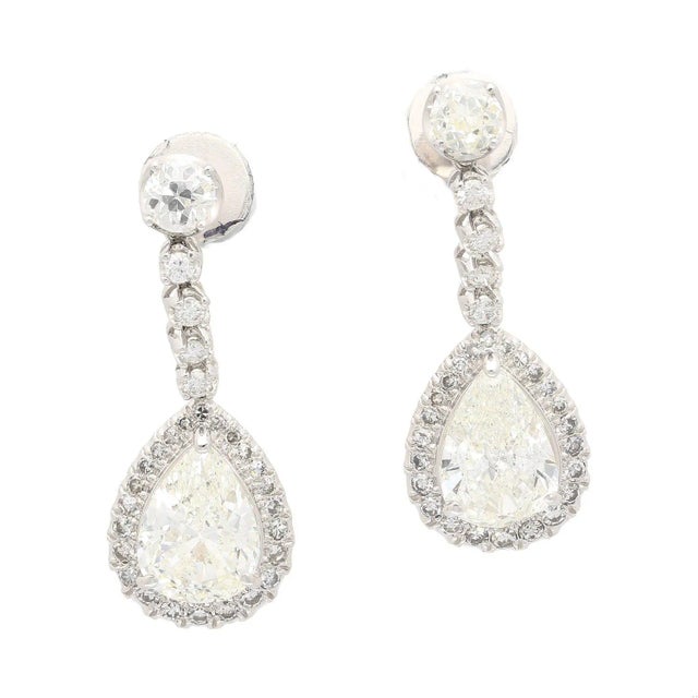 Adorn yourself with these luxurious drop earrings crafted from 18K white gold. The contemporary design and prong setting...