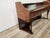 A 1950s-style dressing table or entryway cabinet with an elegant and refined design, clad in burl wood that enhances the...